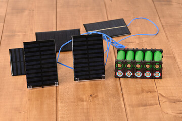 Li ion 18650  battery holder and solar panel on the wooden table.