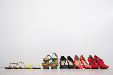 A row of different women's shoes on a white background