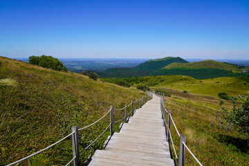 Fototapeta na wymiar wooden pathway tourist staircase for access easy on hight mountain Puy de Dôme volcano in Auvergne france