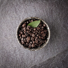 Coffee cup with roasted beans on stone background. Top view with copy space