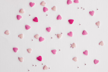 Candies hearts on pink and white paper. Flat lay for Valentine’s Day. Creative sweet concept. Background, top view