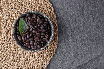 Coffee cup with roasted beans on stone background. Top view with copy space
