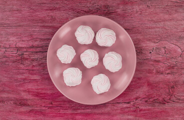 marshmallow on a plate isolated on red background