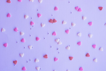 Candies hearts on pink and white paper. Flat lay for Valentine’s Day. Creative sweet concept. Background, top view