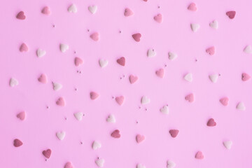 Candies hearts on pink and white paper. Flat lay for Valentine’s Day. Creative sweet concept. Background, top view