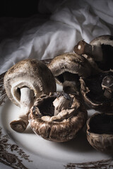 mushrooms mushrooms on a rustic white cloth on a white plate and fork