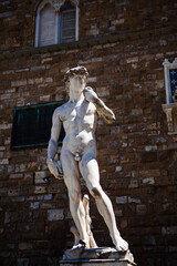 Obraz premium The Italian Renaissance sculpture of The David created in marble by the Italian artist Michelangelo in Florence, Tuscany, Italy. Close up street view. European art and outdoor decor.