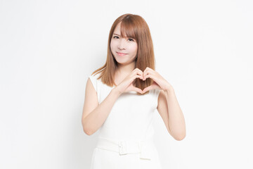 手でハートの形を作る若い女性