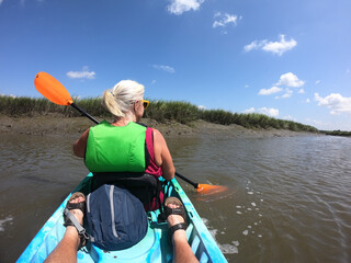 Kayaking in murky inlet with orange paddles