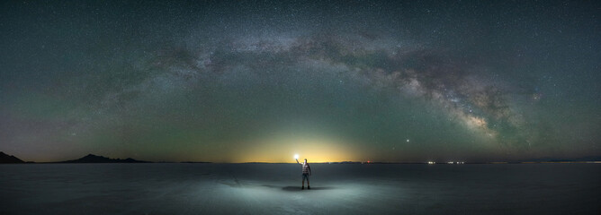 Milky Way Galaxy panorama over Bonneville Salt Flats and a night hiker