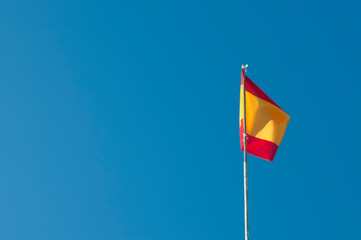 Flatternde Landesfahne Spanien in gelb rot am blauen Himmel