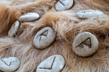 Stone runes on a animal fur. Futhark viking alphabet. Close up photo of Norse runes.