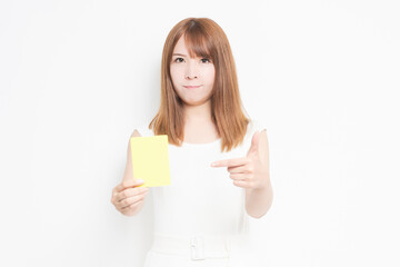 Fototapeta premium イエローカードを手に持つ若い女性