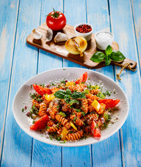Fusilli with tomato sauce, meat and parmesan on wooden table

