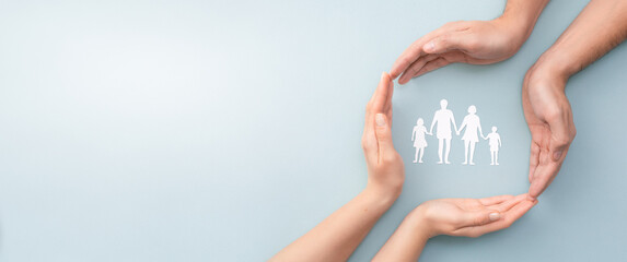 Family care concept. Hands with paper silhouette on table. - 380989575