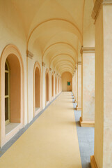 Hallway of columns arches and windows in yellow