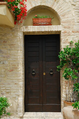 Fototapeta na wymiar Doorway number 3 with potted plants in Montefalco Italy