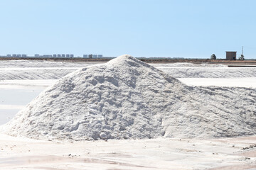 Fototapeta na wymiar Sea salt pile ready for harvest in Marismas del Odiel wetlands. Sea salt is salt that is produced by the evaporation of seawater. Traditional and natural salt production in nature reserve, in Huelva