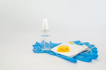 blue medical gloves, respirator and antiseptic on white. Virus protection.