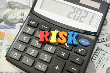 word "risk" laid out from colored letters on the calculator. Financial concept. Economic risk concept.