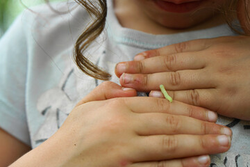 inchworm crawling on the back of a young girl's hands