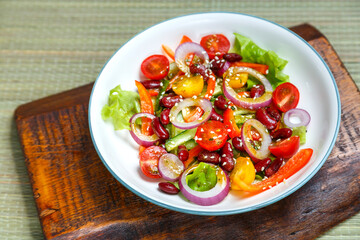 A plate with pan-Asian salad with sesame seeds on wooden stands.