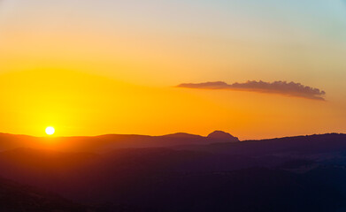 orange sunset sunrise with cloud and mountains in silhouette