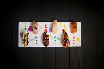 Top view of Asian Nigiri Sushi Set served on white Japanese plate decorated with colorful painting...