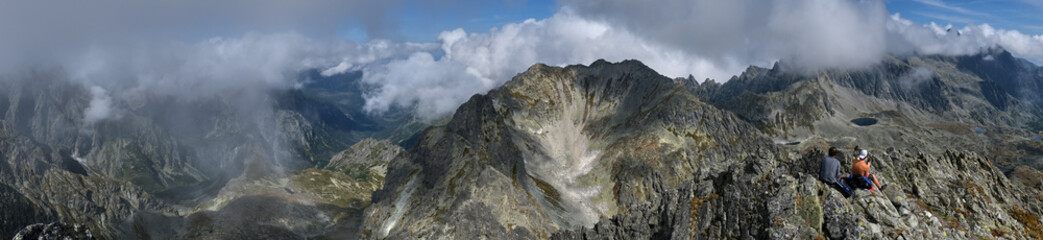 Tourists sitting on the top of mountains - panorama of High Tatras