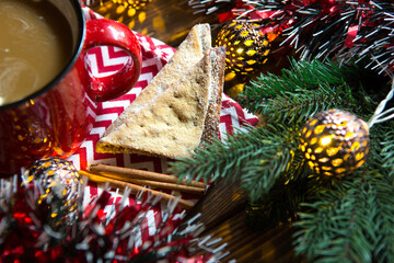 Triangular cookies with powdered sugar and cinnamon on a napkin with a zigzag pattern in the...