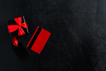 Obraz premium Black label, credit card and gift box on a dark leather.