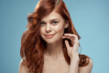 Beautiful woman curly long hair smooth hairstyle naked shoulders cosmetics care blue background