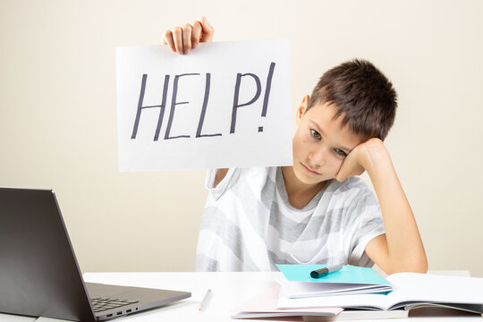 Learning Difficulties, School, Education, Online Remote Learning Concept. Tired Frustrated Boy Sitting At Table And Holding Card With Word