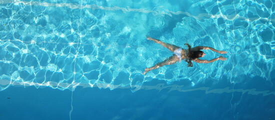 Sporty woman swimming in a pool - view from above