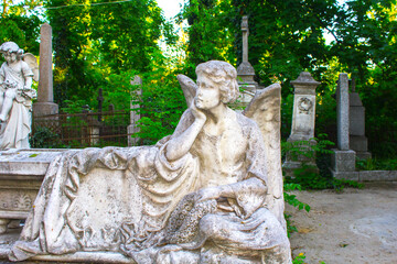 Figure of a praying angel. A very ancient stone statue. Death. Sad angel as symbol of pain, fear...