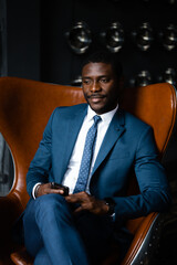 Portrait of a man businessman in a classic suit sitting in a loft aviator chair