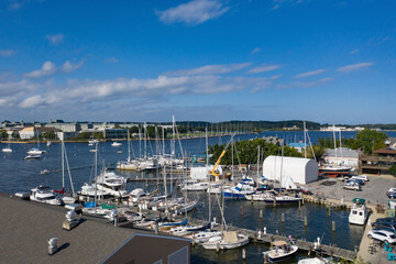 Fototapeta na wymiar Aerial view of colorful sailboat moorings and docks on azure blue Spa Creek, in historic downtown Annapolis Maryland on a sunny summer day