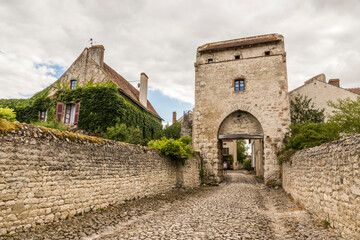 Charroux, France. Half-timbered house and church tower in one of the most beautiful villages in the...