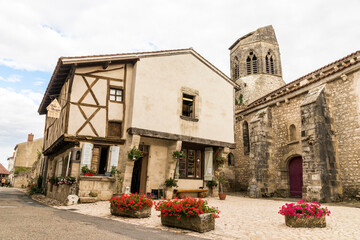 Charroux, France. Half-timbered house and church tower in one of the most beautiful villages in the...