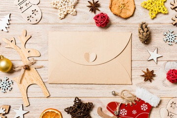 Top view of envelope on festive wooden background. Christmas toys and decorations. New Year time concept