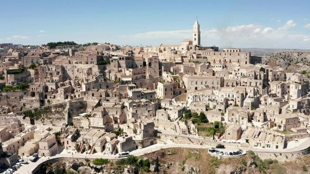 Aerial panoramic view of the ancient town of Matera (Sassi di Matera) in beautiful golden morning light at sunrise, Basilicata, southern Italy. Gorgeous old town from above. Magical Italy.