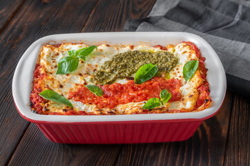 Lasagne topped with tomato sauce and pesto