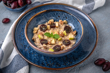 Breakfast of oatmeal with fruit. Natural delicious food. Greek cuisine menu. Still life in a marine style on a blue background.