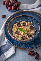 Breakfast of oatmeal with fruit. Natural delicious food. Greek cuisine menu. Still life in a marine style on a blue background.