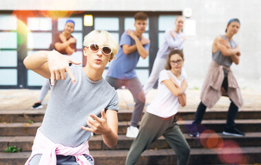 Fototapeta premium Happy positive teenagers learn dance movements at city street