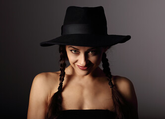 Beautiful fun positive young woman in style blue hat smiling on dark shadow background. Closeup portrait. Halloween