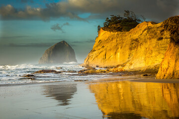Cape Kiwanda und Haystact Rock spiegelten den nassen Sand am Strand von Pacific City an der Küste von Oregon wider. © Bob