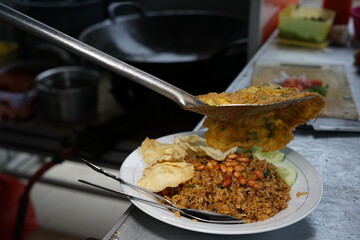 Chef preparing fried rice with fried egg at street food market