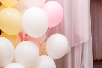 Colorful balloons, party background. Baloons of pale pink, yellow and white color. Pink curtain