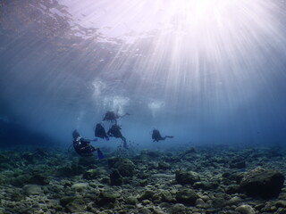 scuba divers exploring the reefs and underwater with rocks ocean scenery enjoying topography mediterranean sea